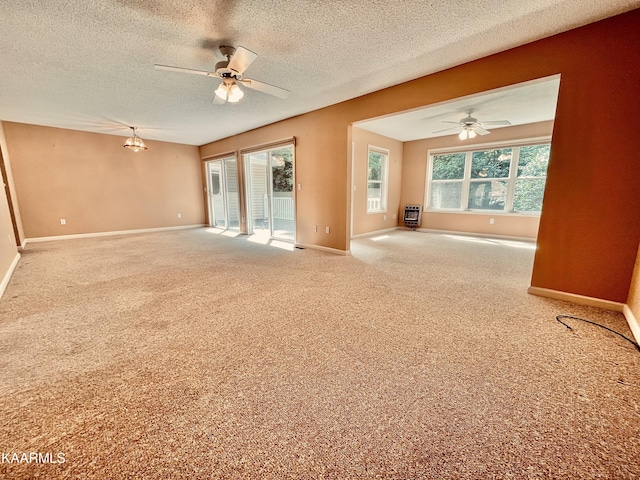 carpeted spare room with a textured ceiling and ceiling fan with notable chandelier