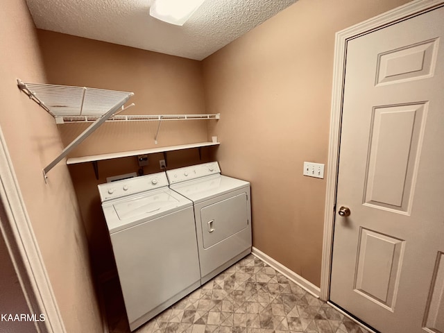 laundry room featuring light tile floors, a textured ceiling, and separate washer and dryer