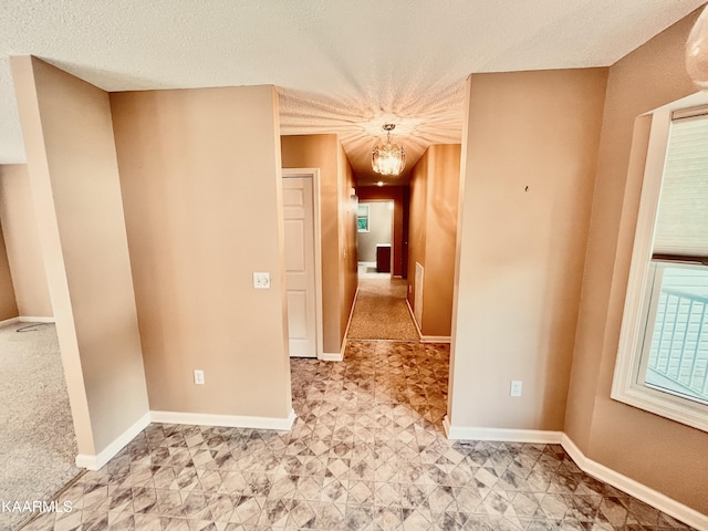 unfurnished room with an inviting chandelier, light tile flooring, and a textured ceiling