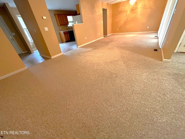 unfurnished living room featuring light colored carpet