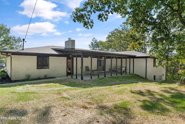 rear view of house featuring a yard and a patio