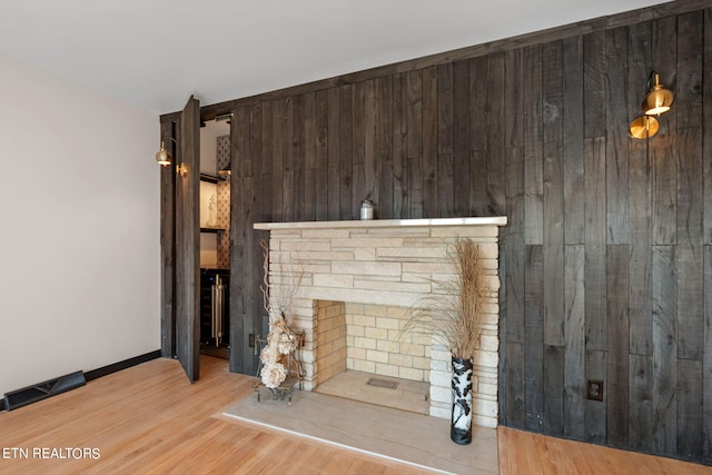 details with wood walls, wood-type flooring, and a fireplace