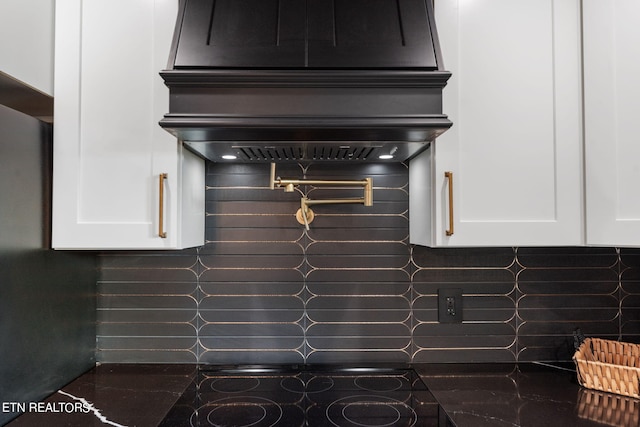 interior details with black stovetop and tasteful backsplash