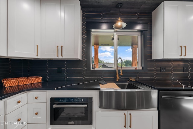 kitchen with black oven, decorative backsplash, and white cabinetry