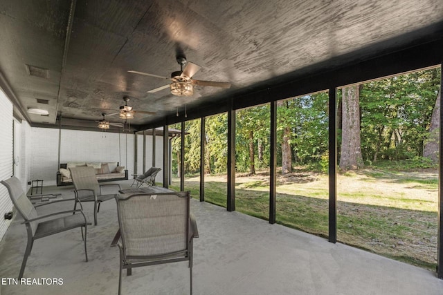 unfurnished sunroom featuring ceiling fan