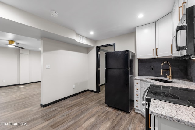 kitchen featuring white cabinetry, light hardwood / wood-style flooring, black appliances, sink, and decorative backsplash