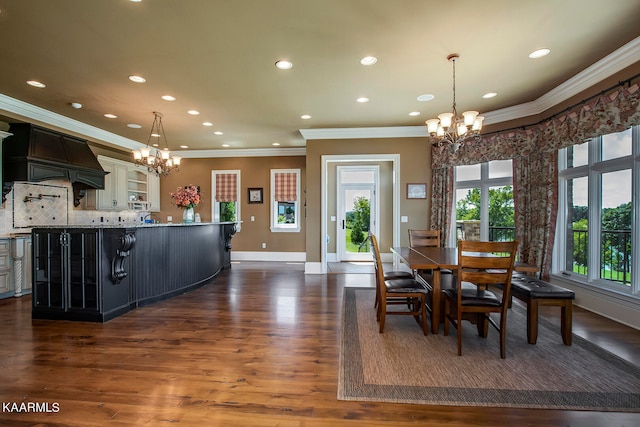 dining room with ornamental molding, dark hardwood / wood-style flooring, and a notable chandelier