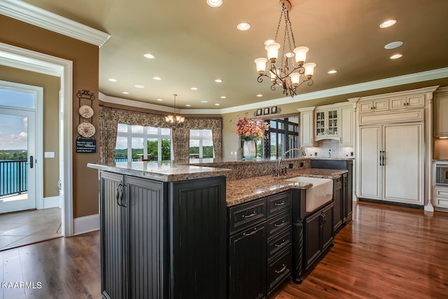 kitchen featuring a large island, decorative light fixtures, and a healthy amount of sunlight