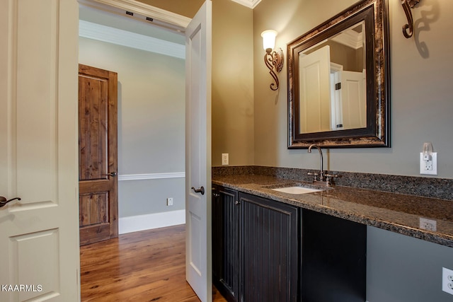 bathroom with hardwood / wood-style flooring, vanity, and crown molding