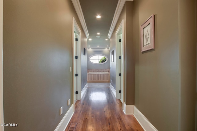 hallway with wood-type flooring and crown molding