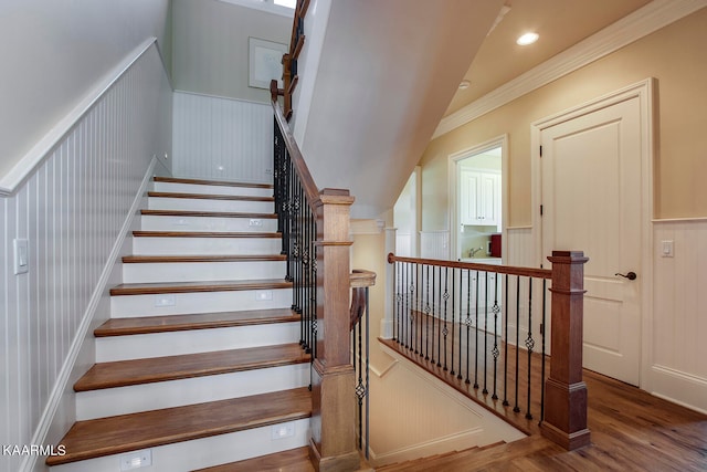 stairway featuring crown molding, vaulted ceiling, and wood-type flooring