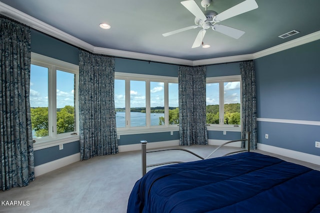 carpeted bedroom with crown molding, multiple windows, and a water view