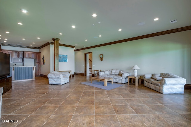 tiled living room with decorative columns and ornamental molding