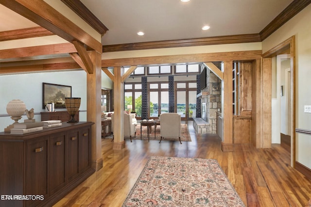 living room featuring dark wood-type flooring, beamed ceiling, crown molding, french doors, and decorative columns