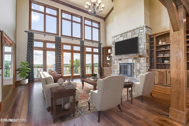 living room with a towering ceiling, a fireplace, dark hardwood / wood-style flooring, ornamental molding, and a notable chandelier