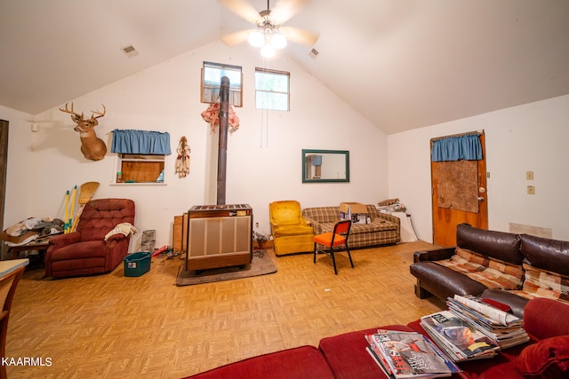 living room with a wood stove, ceiling fan, light parquet floors, and lofted ceiling