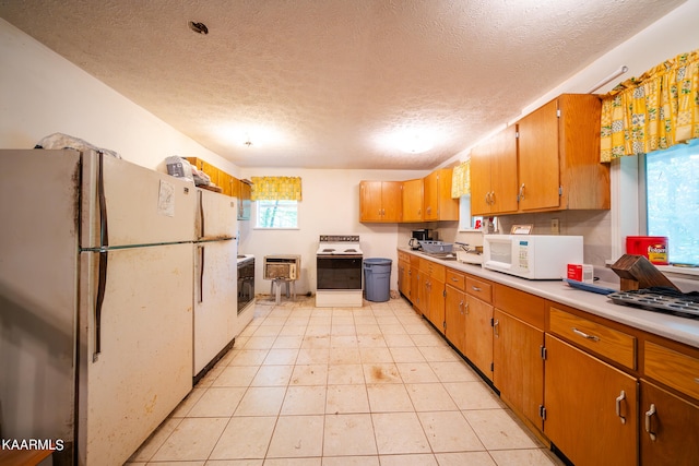 kitchen with white appliances, sink, a textured ceiling, and light tile flooring