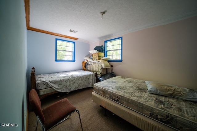 carpeted bedroom with crown molding and a textured ceiling