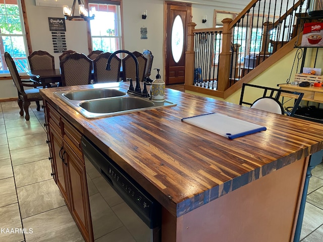 kitchen featuring sink, butcher block countertops, dishwasher, and a kitchen island with sink