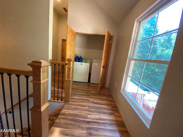 hallway featuring washer and dryer, dark hardwood / wood-style flooring, and lofted ceiling