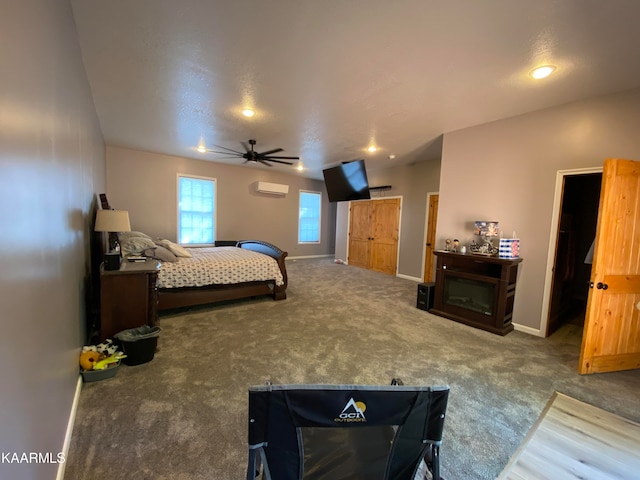 carpeted bedroom featuring ceiling fan, a spacious closet, and a textured ceiling