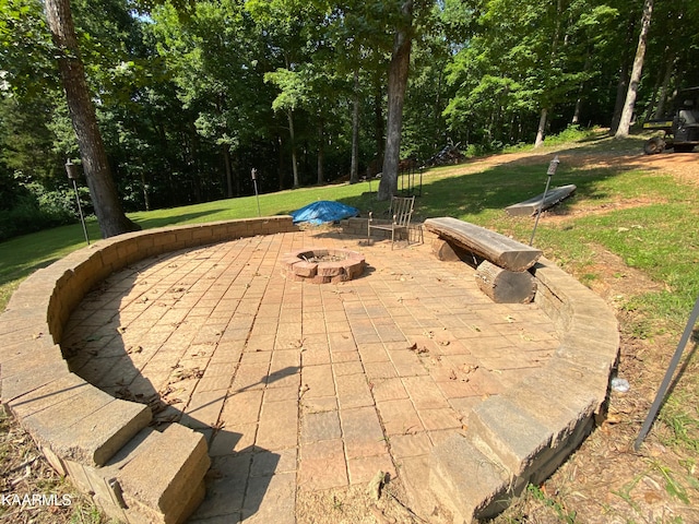 view of property's community featuring a yard, a patio area, and a fire pit