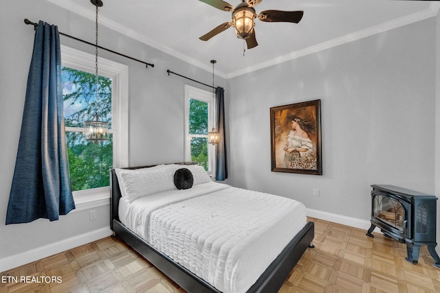 bedroom with multiple windows, a wood stove, and ceiling fan