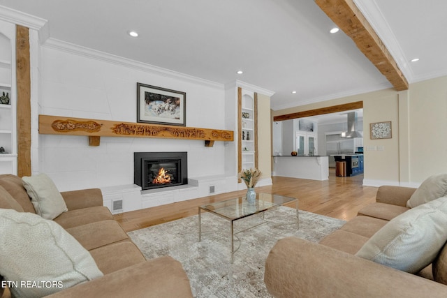 living room featuring light wood-type flooring, built in features, and ornamental molding