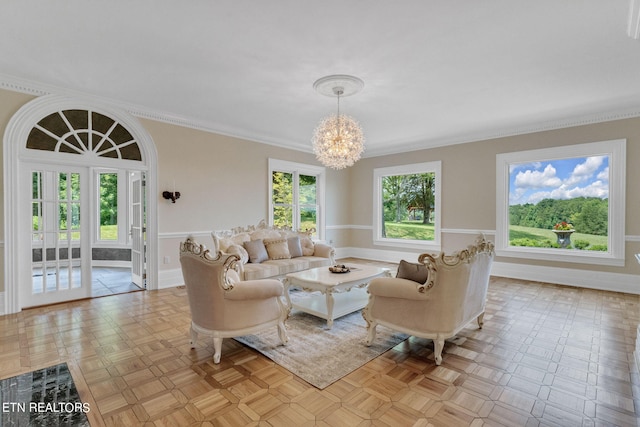 living room with a notable chandelier, ornamental molding, and light parquet flooring