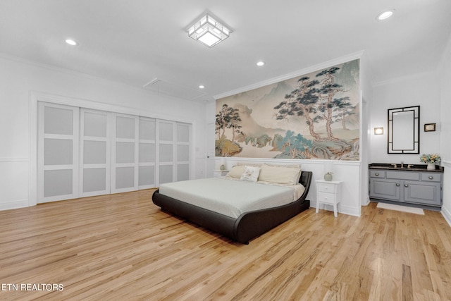 bedroom with crown molding and light hardwood / wood-style floors