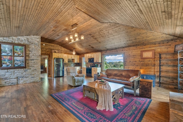 living room with hardwood / wood-style floors, a notable chandelier, wood walls, and wooden ceiling