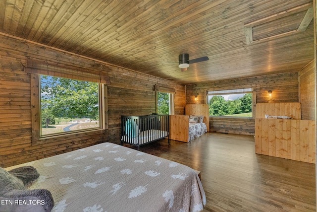 bedroom featuring dark hardwood / wood-style flooring, wooden walls, and wood ceiling