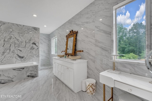 bathroom with vanity, a bathtub, and tile walls