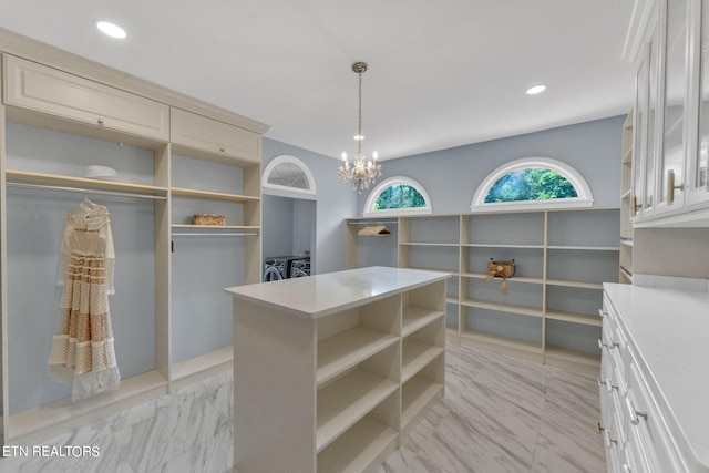 spacious closet featuring a chandelier