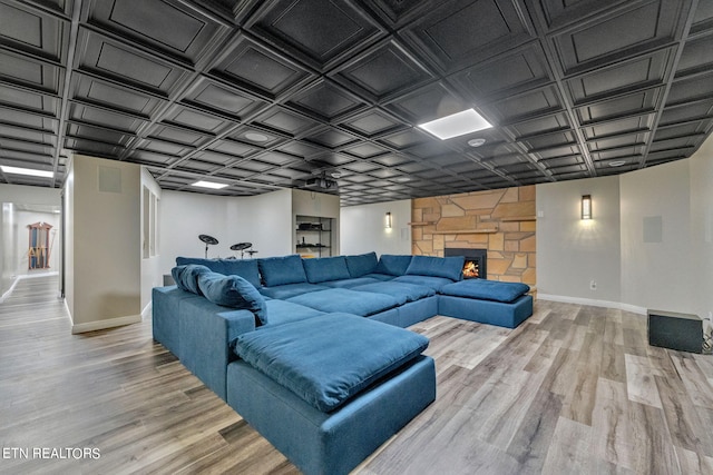 living room with hardwood / wood-style flooring and a stone fireplace