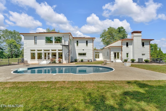 rear view of property with a yard, central AC, and a patio area