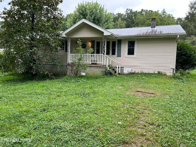 single story home featuring covered porch and a front yard