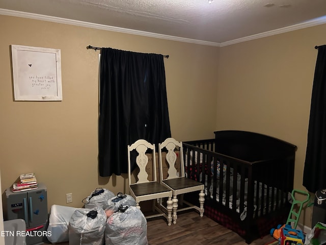 bedroom featuring crown molding, a crib, and dark hardwood / wood-style floors