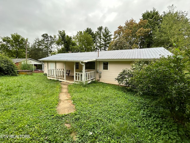 rear view of house featuring a yard