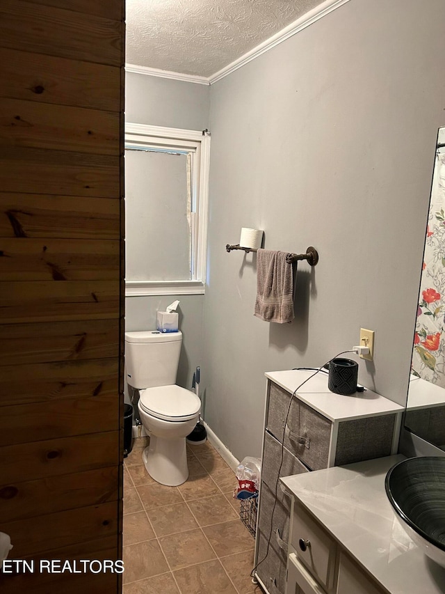 bathroom with toilet, ornamental molding, tile flooring, a textured ceiling, and vanity