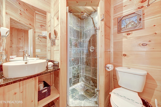 bathroom with toilet, vanity, tiled shower, wooden walls, and wood ceiling