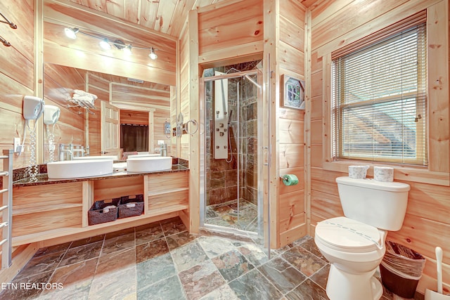 bathroom featuring a shower with door, vanity, and wooden walls