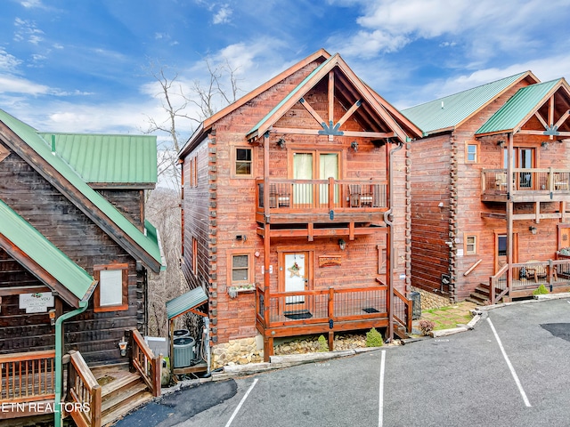 view of front of home featuring a balcony and central AC unit