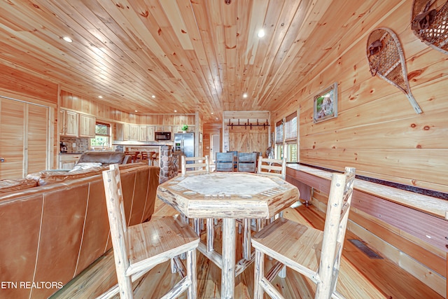 dining area with wood ceiling and wooden walls