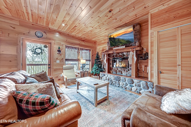 living room featuring wooden walls, a fireplace, and wood ceiling