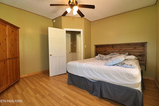 bedroom featuring ceiling fan, light wood-type flooring, and vaulted ceiling