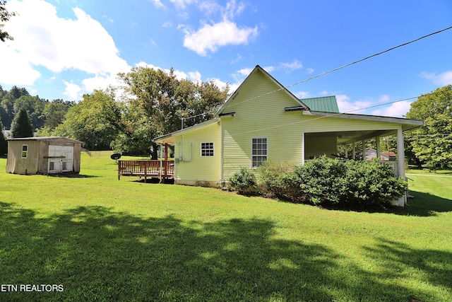 view of side of home with a deck, a yard, and a storage unit