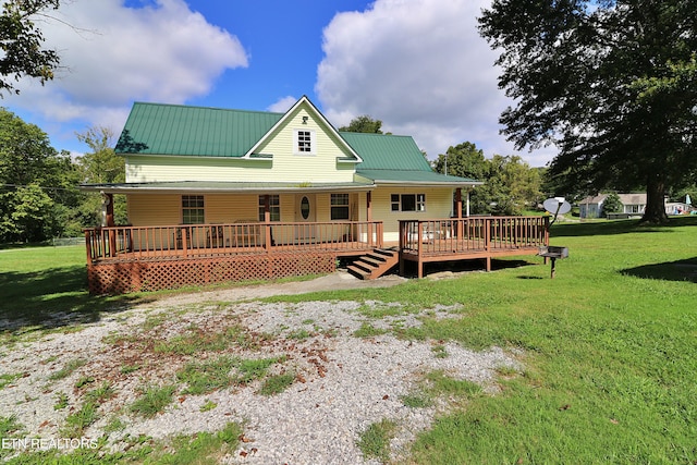 rear view of property with a wooden deck and a yard