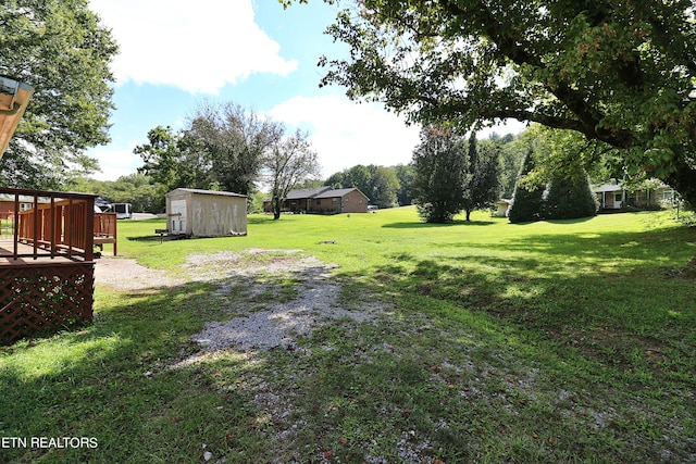 view of yard with a deck and a storage unit