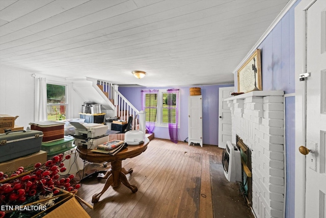 living room with dark hardwood / wood-style floors, a healthy amount of sunlight, and a brick fireplace